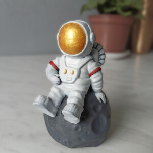 Космонавт сидящий на луне миниатюра
