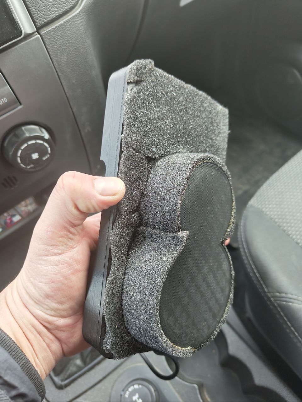 Bir fincan tutucusundaki kablosuz şarj bazusuna dayanan UAZ Patriot'ta bir telefon için bir platform. (Plastik Aparattır!!!)