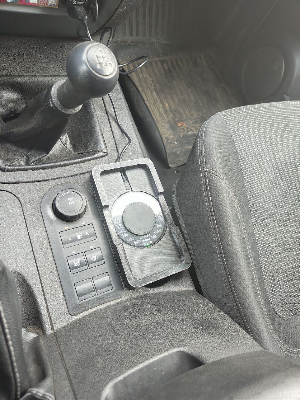 Bir fincan tutucusundaki kablosuz şarj bazusuna dayanan UAZ Patriot'ta bir telefon için bir platform. (Plastik Aparattır!!!)